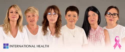 Six women in white attire stand side by side, with a pink ribbon symbol for breast cancer awareness. The text reads "International Health."